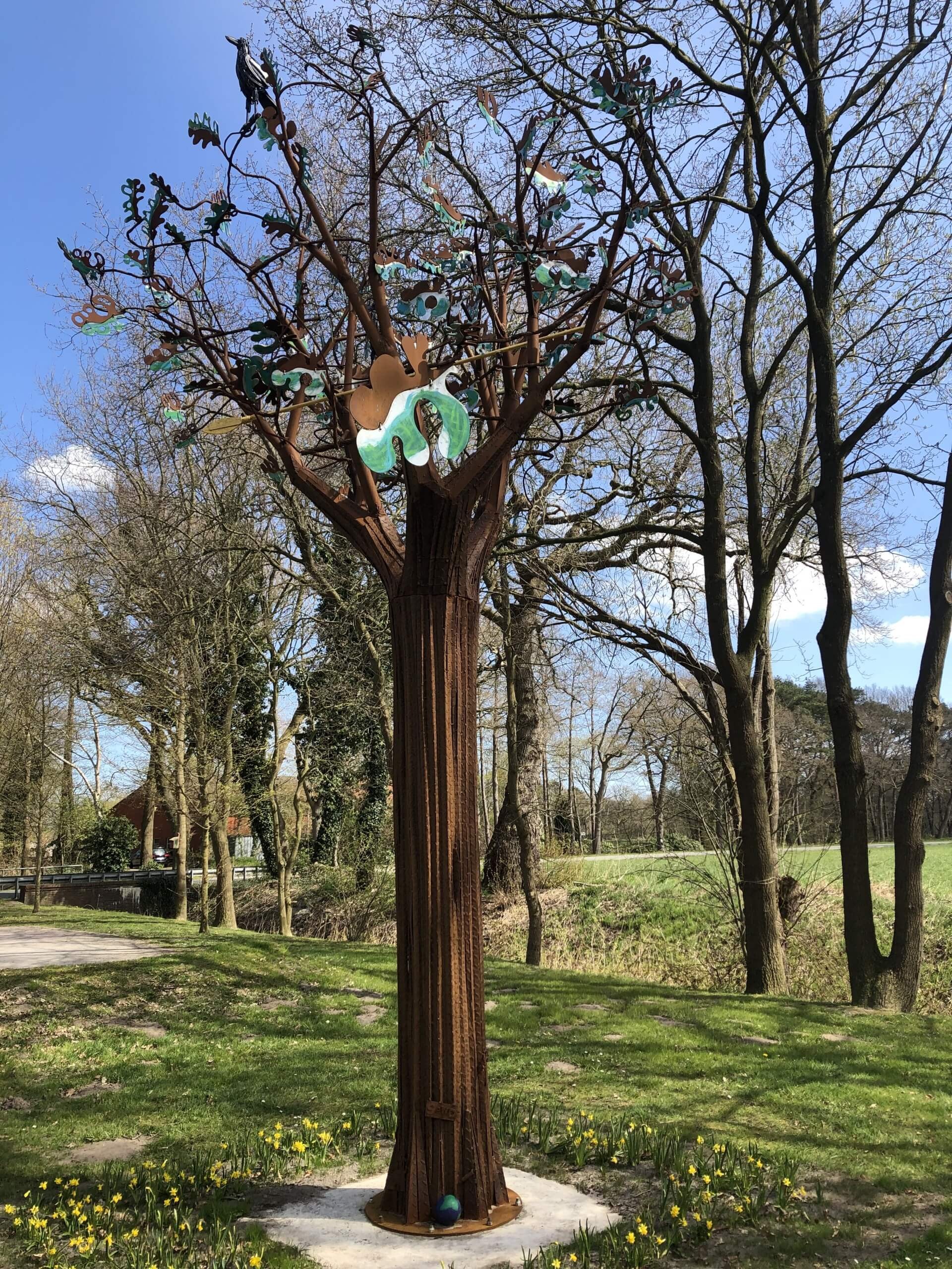 Auf einer Grünfläche steht ein nachgebildeter Baum aus Eisen 
