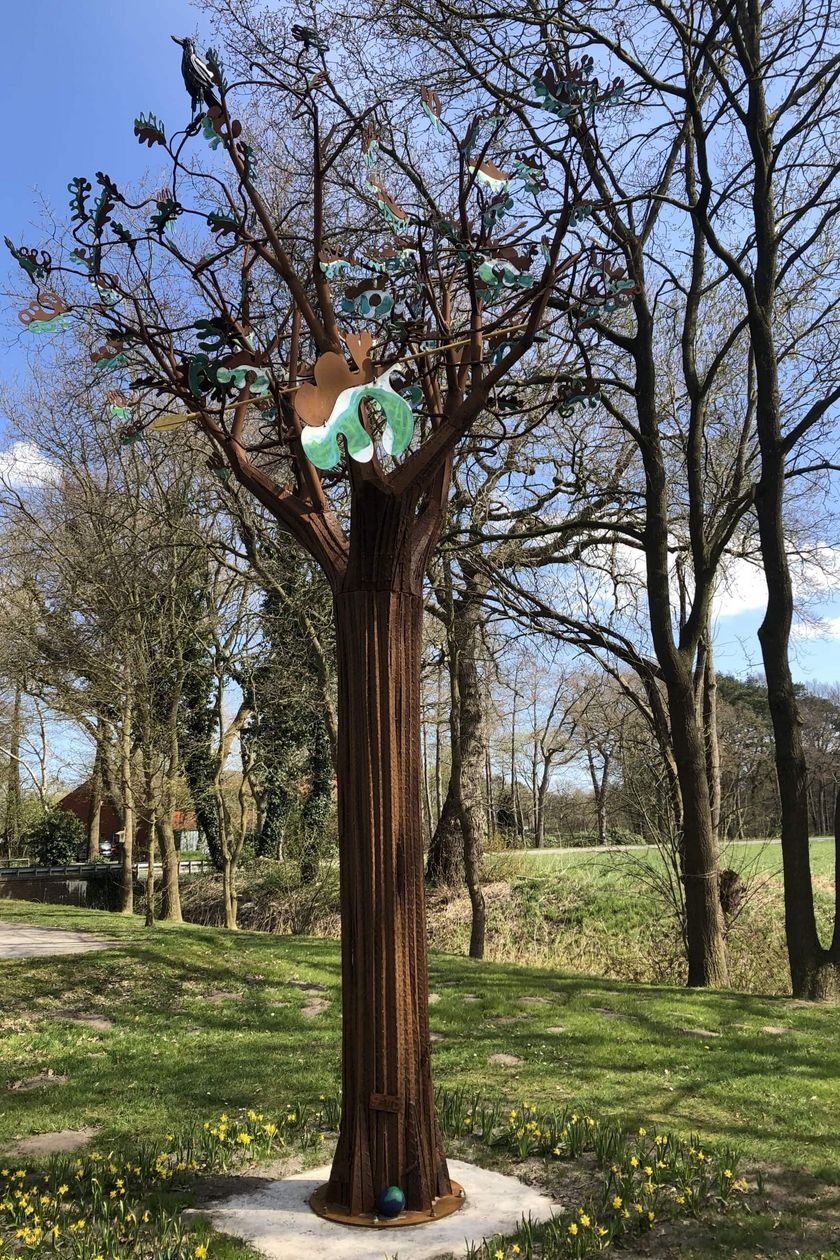 Auf einer Grünfläche steht ein nachgebildeter Baum aus Eisen 