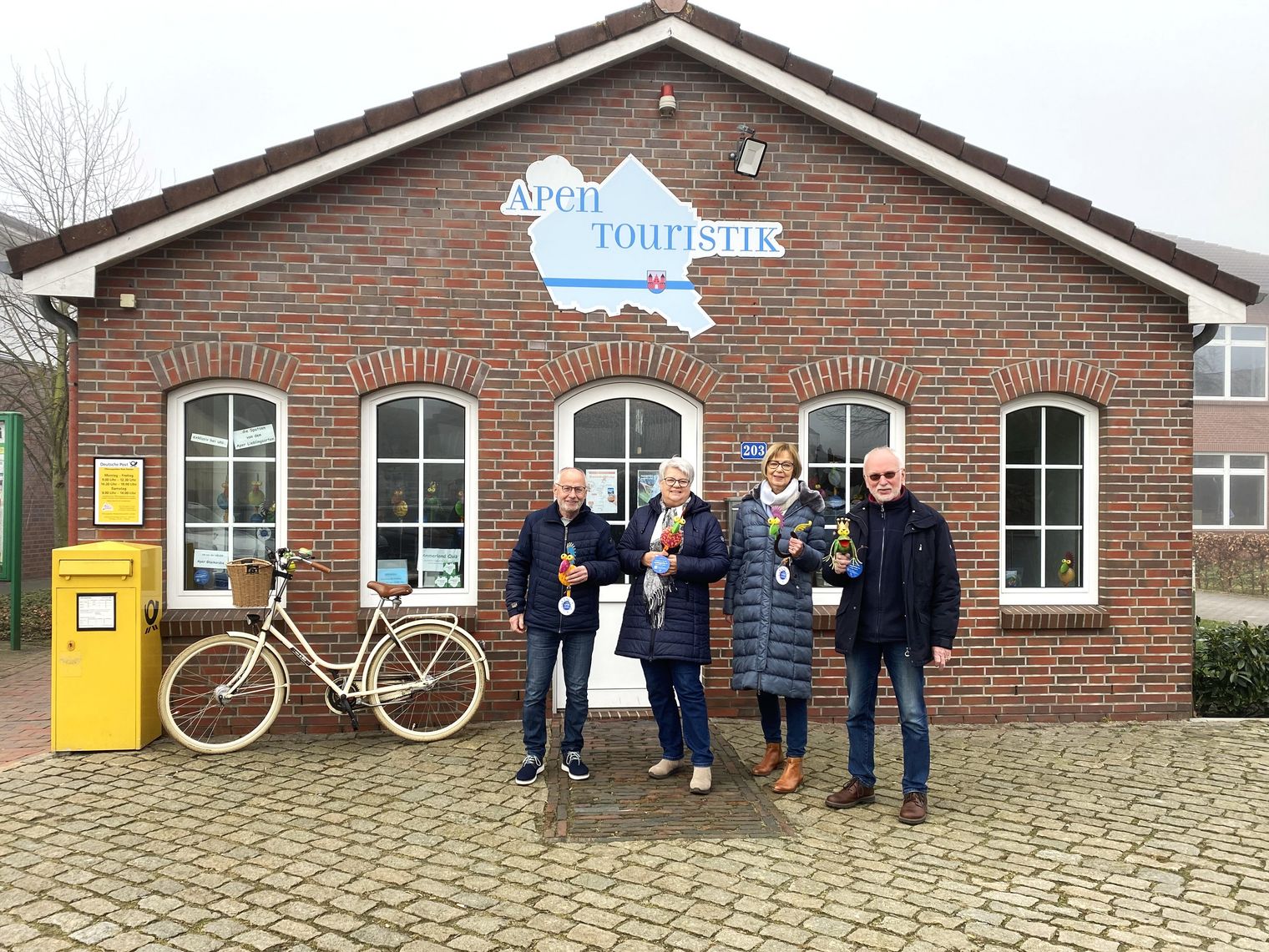 Alle Gästeführer der Apen Touristik stehen vor der Tourist Info und schauen in die Kamera.