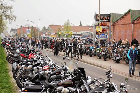 Das Bild zeigt aufgereihte Motorräder auf einer Straße während einer Veranstaltung.