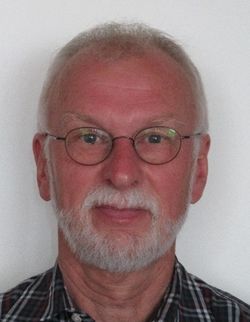 Porträt eines älteren Herrn mit Brille und grauem Bart vor hellem Hintergrund